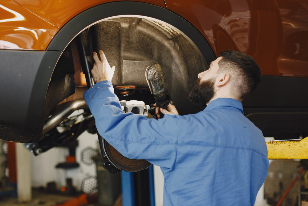 mechanic checking wheel aligment of a vehicle